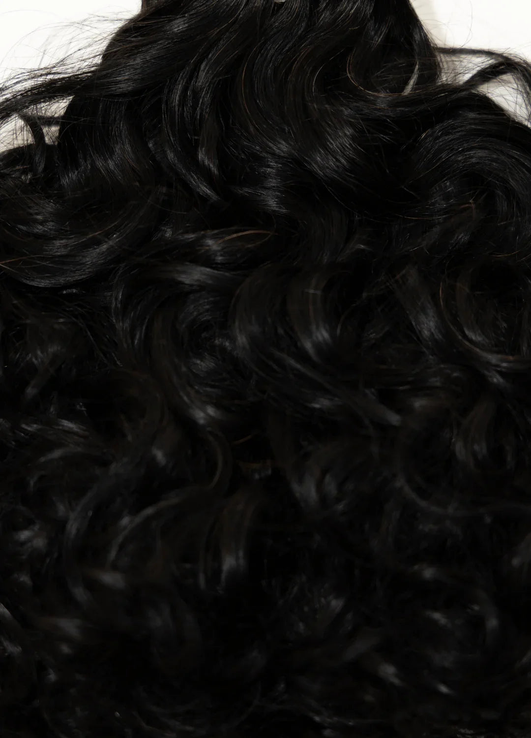 Cheveux noirs bouclés et brillants en gros plan texture naturelle