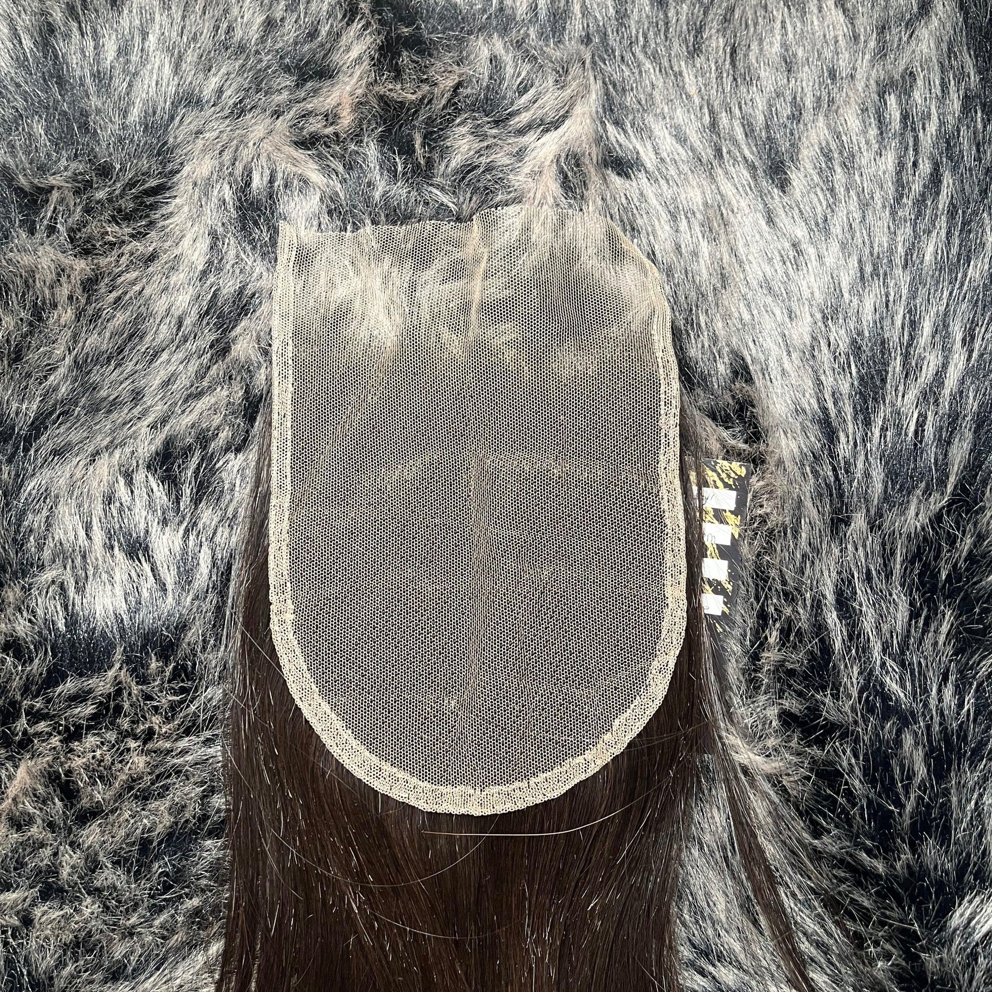 Closure en dentelle transparente sur cheveux bruns foncés avec arrière-plan en fausse fourrure grise